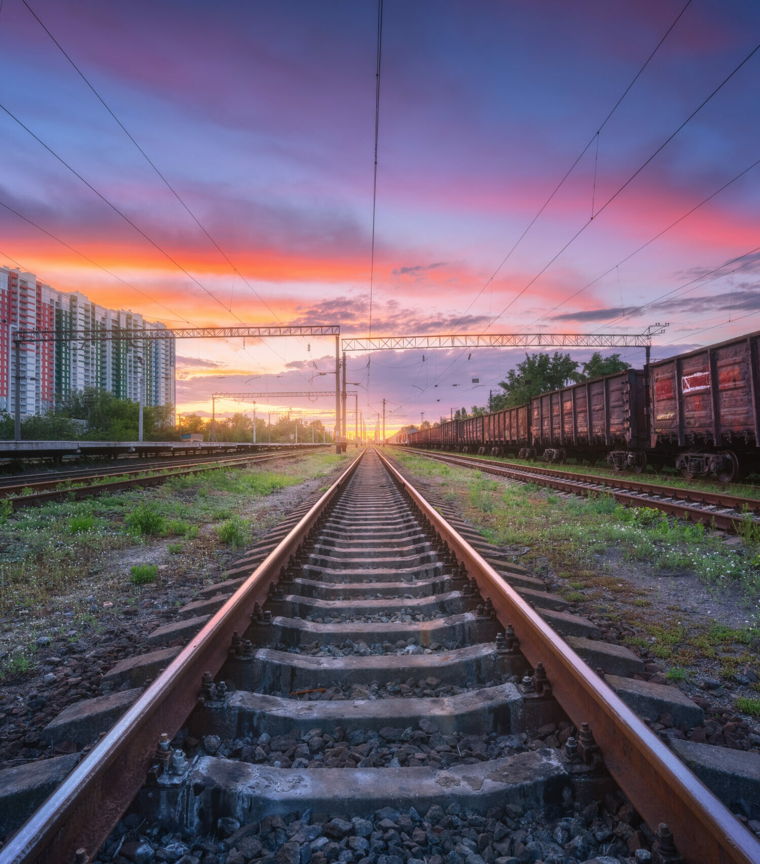 Railway station with freight trains at sunset